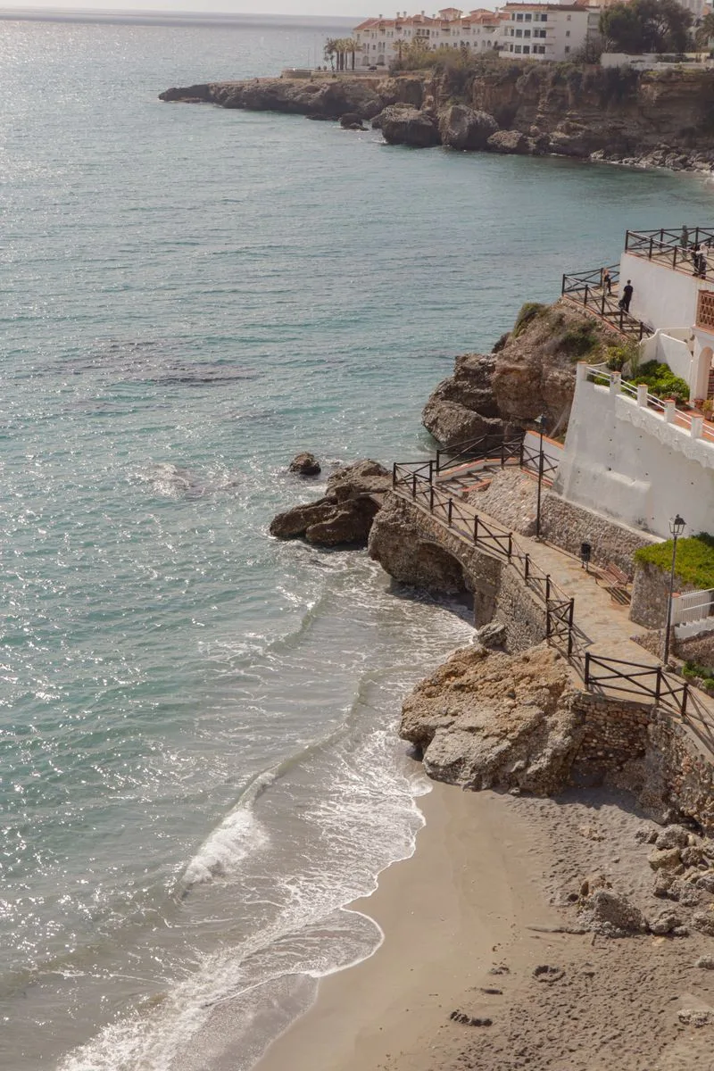 A picturesque coastal landscape with white buildings atop rocky cliffs overlooking the sea.
